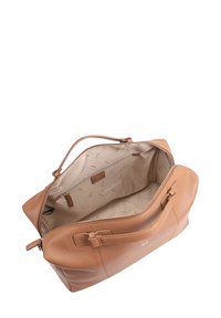 Sac en cuir tan avec un extérieur robuste et une fermeture à glissière. L'intérieur doublé présente un motif subtil, ainsi qu'une poche zippée et un onglet.