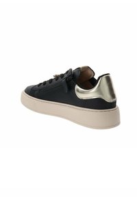 Sneaker in pelle nera con un accento metallico argento sul tallone. Presenta una suola spessa di colore neutro e lacci neri con dettagli in zip.