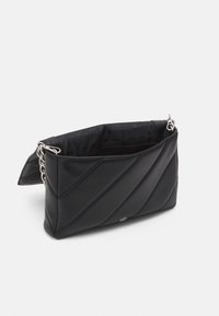Czarna, pikowana skórzana torebka na ramię z srebrnym łańcuszkiem, wewnętrzną kieszenią na zamek błyskawiczny oraz zapięciem na zatrzask magnetyczny, wyściełana markowym materiałem.