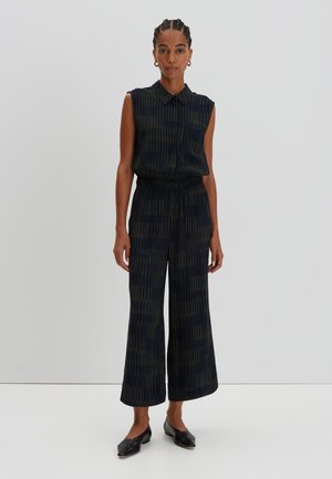 Sleeveless, collared jumpsuit in dark navy with green vertical stripes; loose fit with an elastic waistband; cropped wide-leg trousers.