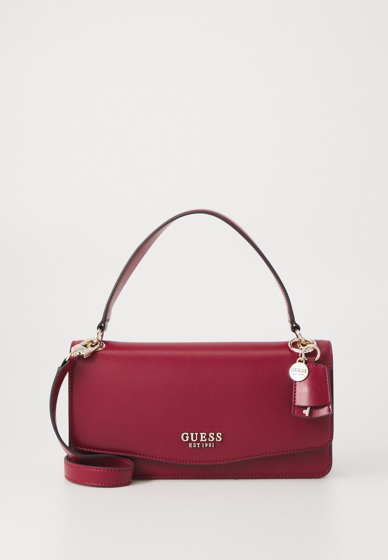 Borsa a mano in pelle bordeaux con logo dorato, tracolla removibile e un etichetta piccola. Texture liscia e forma rettangolare strutturata.