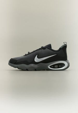 Baskets Nike noires et grises avec le logo blanc, dessus en mesh et synthétique, coussin d'air visible dans la semelle, présentées sur un fond neutre.