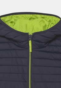 Černá prošívaná bunda se zeleným zipem a zelenou vnitřní podšívkou, s kapucí a vodorovným vzorem šití.