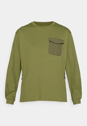 Camisa de manga larga verde oliva con un acabado texturizado, que cuenta con un gran bolsillo delantero y cremalleras laterales para ajustabilidad.