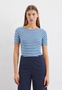 Cotton t-shirt with blue and white horizontal stripes, round neckline, and short sleeves, paired with navy high-waisted trousers.