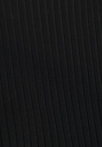 Svart ribbat tyg med vertikala linjer, texturerad yta, medelhårdhet, mjukt utseende, lämpligt för kläder eller möbler.