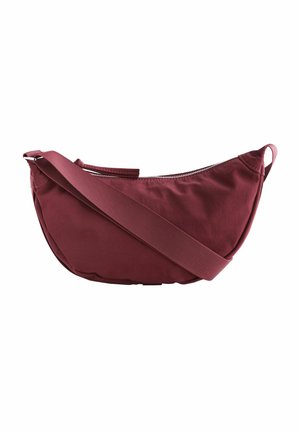 Bordeaux farvet stof skuldertaske med en buet form, lynlåslukning og en bred justerbar rem. Glat tekstur, minimalistisk design.