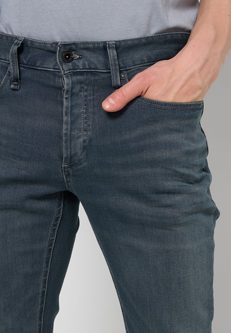 Donker indigo spijkerbroek met een slim fit, voorzien van een klassieke vijf-pocket ontwerp, tonale stiksels en een soepele, licht gestructureerde stof.