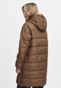 Brun puffer-jakke med hætte, der har quiltede sektioner, lange ærmer og knaplukninger i sideslidsene for justerbarhed. Glat tekstur.