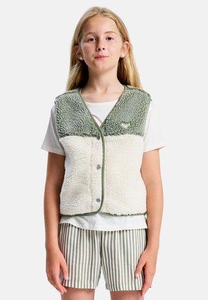 Fleecevest met groene en crèmekleurige panelen, met een zachte textuur, een afgeronde kraag en knoopsluitingen; gedragen over een wit overhemd en gestreepte korte broek.