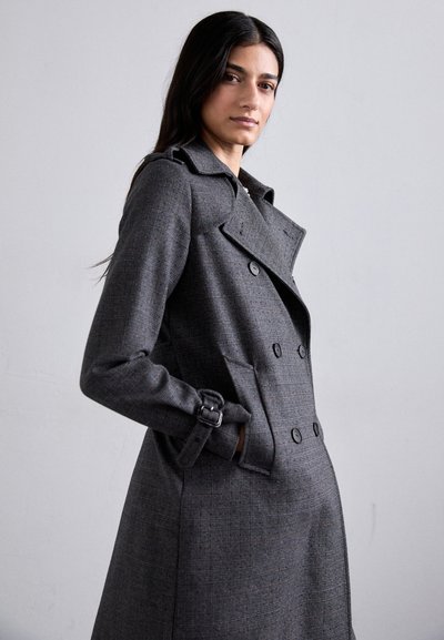 Grau doppelt geknöpfter Trenchcoat mit strukturiertem Muster, breitem Kragen, Seitentaschen und Schnallenakzenten an den Ärmeln.