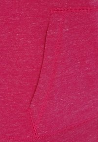Tissu en mélange de coton fuchsia avec une texture douce. Dispose d'une poche latérale et de détails de coutures visibles. Convient pour une tenue décontractée.