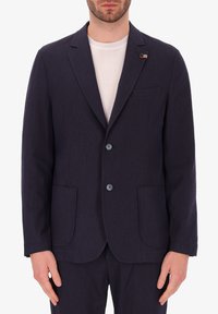 Blazer di un blu navy scuro realizzato in tessuto strutturato, dotato di due tasche frontali, una tasca sul petto e due bottoni. Stile casual con rever a punta.