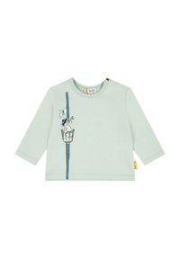 Maglietta lunga verde chiaro per bambini in tessuto morbido. Presenta una stampa di un gatto in un cesto con un telescopio e una striscia verticale blu.
