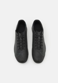 Black athletic shoes with a textured upper, central lace closure, and subtle blue accents. Designed for performance, featuring a streamlined shape.