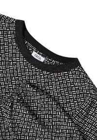 Top a fantasia bianca e nera con scollatura rotonda, dettaglio elastico e texture del tessuto liscia. L'etichetta riporta "CECIL."