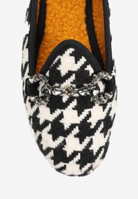 Czarno-białe płaskie buty w wzór houndstooth z okrągłym noskiem. Posiadają teksturowaną pomarańczową wkładkę oraz akcent w postaci zdobionej klamry.
