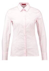 Chemise femme rose clair à manches longues avec boutons, col pointu et taille cintrée, présentée sur fond blanc.