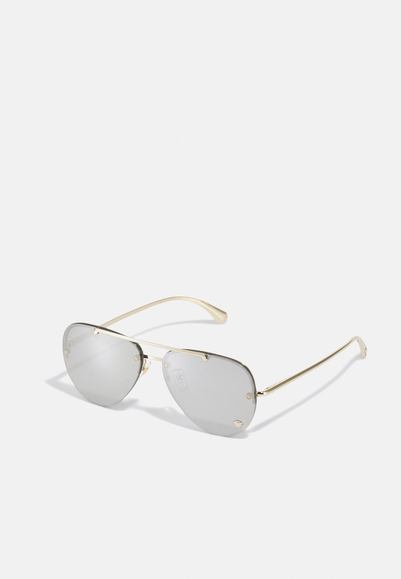 Grey-tinted sunglasses with a gold metal frame, angular shape, and prominent nose pads. Features small gold accents on the frame.