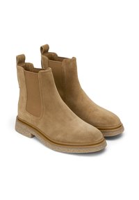 Bottines en daim marron clair avec panneaux latéraux en élasthanne, bout arrondi et semelle en caoutchouc texturé. Possède des languettes pour un enfilage facile.