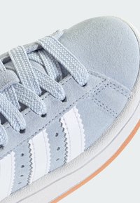 Svijetloplavi tenisica od brušene kože s bijelim kožnim prugama, okruglim vrhom, teksturiranim vezicama i gumenim đonom s srednjim slojem u boji gume.