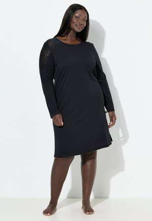 Musta pitkähihaista mekkoa pehmeästä kankaasta, jossa on pitsikoristeet olkapäillä. Mekossa on pyöreä kaula-aukko ja sivureiät liikkumista varten.