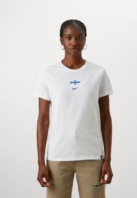White cotton t-shirt with a blue graphic design featuring "N" and "Nike" logo. Short sleeves, round neckline, and straight hem.