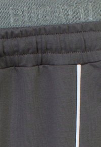 Grauem Hosen mit strukturierten Oberflächen. Elastischer Bund mit dem eingravierten "BUGATTI"-Logo. Weißer Seitenstreifen.