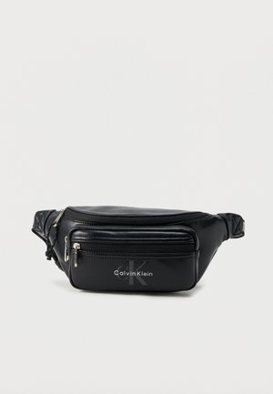Sac banane Calvin Klein en cuir noir avec deux compartiments zippés et bandoulière réglable sur fond clair.