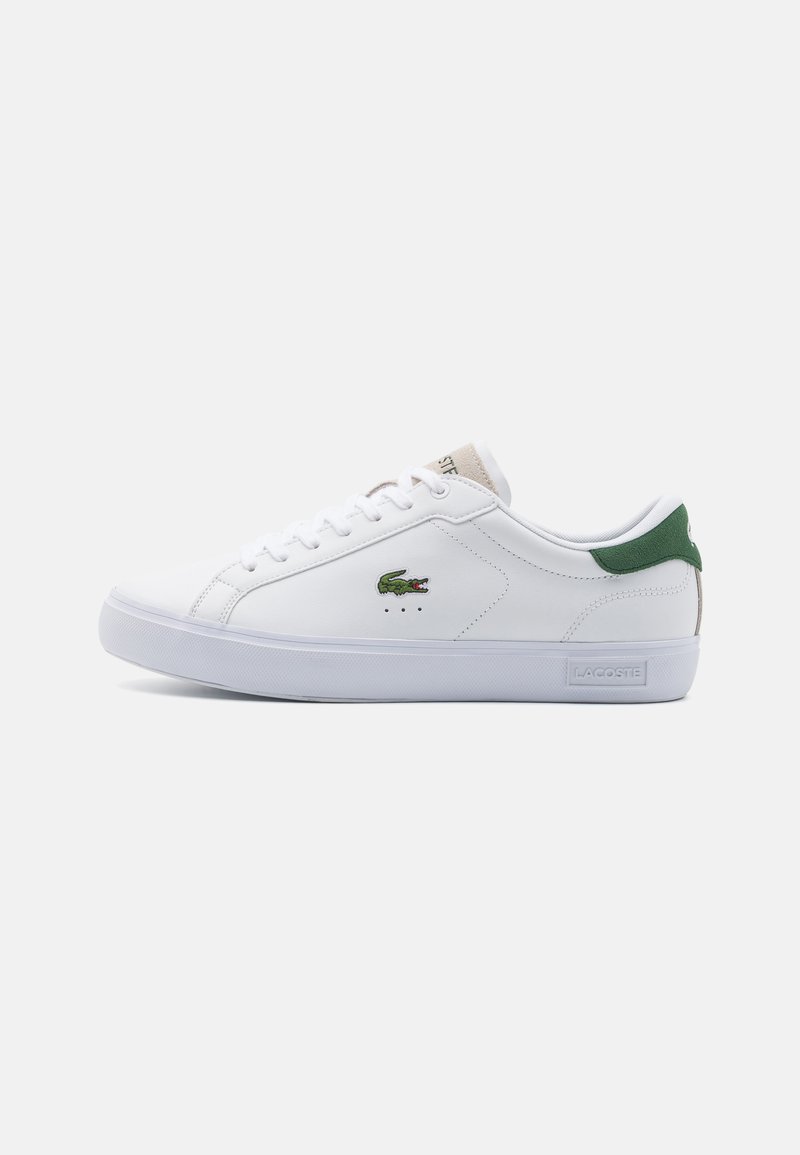 Zapatilla blanca de cuero con un acabado texturizado. Acento verde en el talón, logo bordado en el lateral y suela plana de goma blanca.