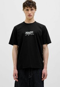 Sort bomulds T-shirt med et hvidt trykt logo "JACK&JONES" i midten. Korte ærmer, rund hals og afslappet pasform.