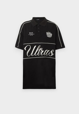 Tricou polo negru cu bordură albă, textul „Ultras” pe partea din față, un mic blazon pe pieptul stâng și „8114 IAN KØBENHAVN EST. 2008” pe pieptul drept.
