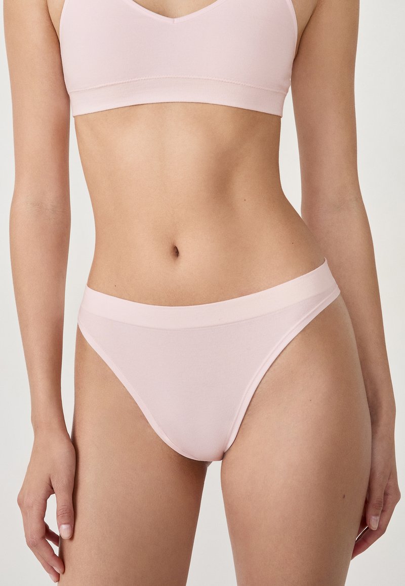 Helle rosa Bralette und passende Slips aus weichem, dehnbarem Stoff. Der Bh hat ein V-Ausschnitt-Design; die Slips verfügen über einen breiten elastischen Bund.