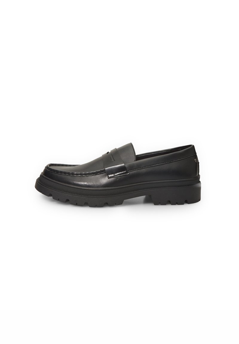 Mocassin en cuir noir avec semelle épaisse et surpiqûres, vue latérale montrant l'empeigne lisse et la semelle extérieure crantée.