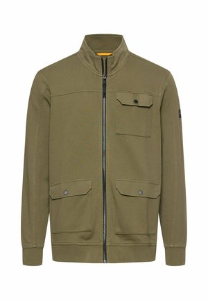 Olivengrøn lynlåstrøje med opretstående krave, tre forlommer med klap og knapper, ribstrikkede manchetter og taljebånd.