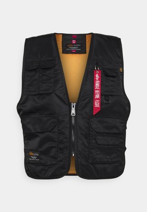 Zwarte vest met meerdere zakken aan de voorkant, ritssluiting en een feloranje binnenvoering. Inclusief een rode "Verwijder voor vlucht" label.