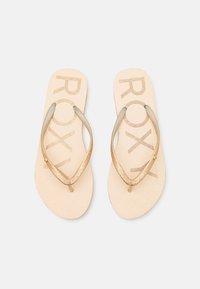 Roxy flip-flops, med en beige bas och ett texturerat mönster samt glittrande guldremmar, som erbjuder en avslappnad och lätt design.