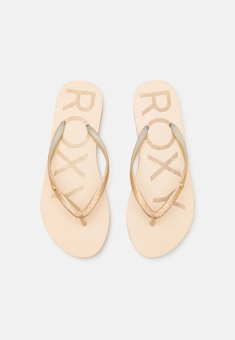 Roxy flip-flops, med en beige bas och ett texturerat mönster samt glittrande guldremmar, som erbjuder en avslappnad och lätt design.