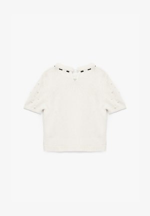 Weißes kurzärmliges Strickoberteil mit V-Ausschnitt, verziert mit dekorativen Perlenakzenten an den Ärmeln und einem kleinen Schlüsselloch hinten mit schwarzer Einfassung.
