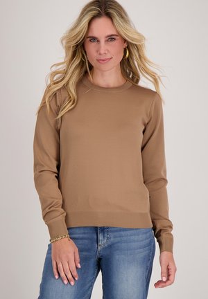Bruin gebreid sweater met een ronde hals en lange mouwen, voorzien van geribbelde manchetten en zoom. Gedragen met lichtblauwe jeans.