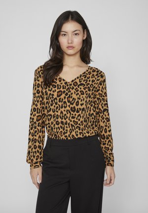 Bluză cu imprimeu leopard în nuanțe de bej și negru, cu decolteu în V, mâneci lungi, manșete gathered și croială lejeră, asortată cu pantaloni negri.
