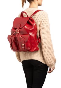 Sac à dos en cuir rouge avec une finition brillante, doté d'un rabat, de deux poches avant et de bretelles réglables. Le design textured ajoute du détail.