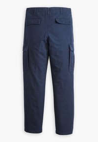 Granatowe spodnie cargo z klapkowymi kieszeniami z tyłu i po bokach, szlufkami na pasek, prostym krojem nogawek i talią z połowy wysokości.
