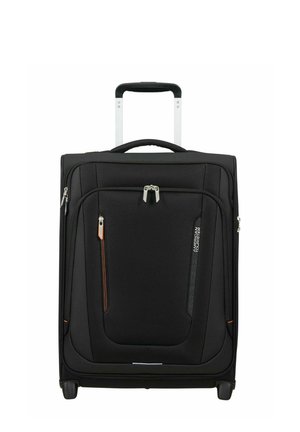 Valise souple noire à position verticale avec poignée télescopique, poches frontales zippées et deux roues pour rouler.