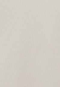 Tissu gris clair côtelé avec des lignes verticales, fabriqué en matériau doux. Texture subtile avec un motif uniforme et sans ornements visibles.