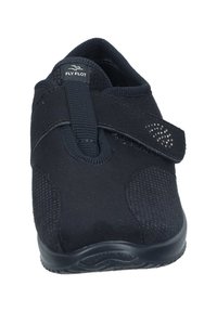 Black slip-on shoe with a textured mesh upper, elastic strap for closure, and a cushioned sole. Features a logo on the tongue and decorative accents.
