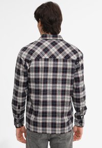 Camicia in flanella a quadri con motivi grigi, blu navy e bordeaux, colletto con bottoni e polsini regolabili, realizzata in un tessuto testurizzato.