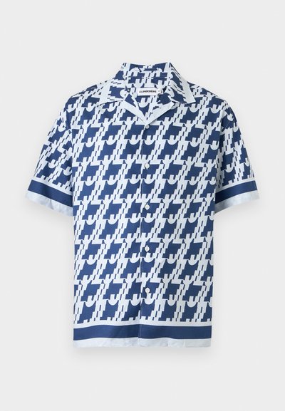 Camisa de manga corta con botones, con patrón geométrico azul y blanco y ribete en contraste en las mangas y el dobladillo.