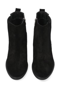 Sorte ankelstøvler i ruskind med en glat, tekstureret overflade, der har lynlås i siden og en rundet tå. Flad sål med minimal slidbane.