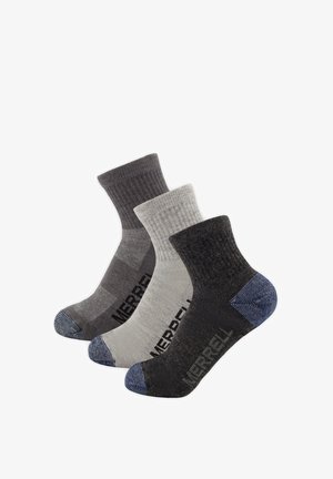 Three Merrell brand crew socks in dark grey, light grey, and black, each with reinforced blue toe and heel areas.